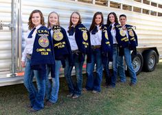 a group of women standing next to each other in front of a trailer with police shirts on