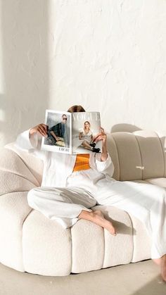 a person sitting on a couch reading a magazine