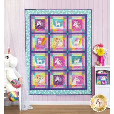 a quilted unicorn themed wall hanging in a child's room