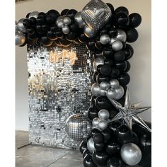 black and silver balloons are arranged in the shape of a christmas tree with a star on top