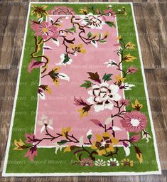 a pink and green rug with flowers on it