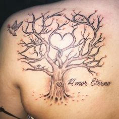 a woman's back with a tree tattoo on it