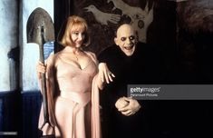 a man and woman dressed in costumes posing for the camera with an evil mask on their face