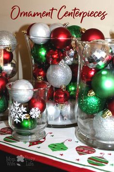 there are many christmas ornaments in glass vases on the table with red and green balls