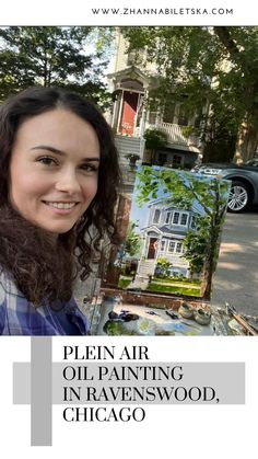 a woman is smiling while holding an oil painting in front of a house and trees