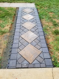 a brick walkway in the middle of a grassy area