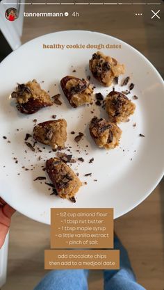 a white plate topped with cookies on top of a wooden table next to a person