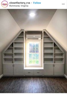 an empty room with built in bookshelves and a window