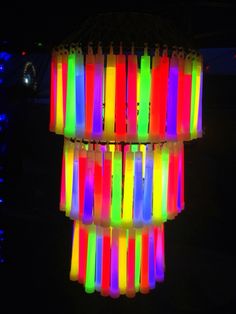 the colorful lights are hanging from the ceiling in the dark, making it look like they have been made out of plastic straws