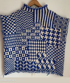 a blue and white sweater hanging on a wall