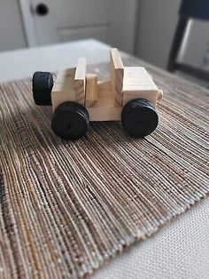 a wooden toy car sitting on top of a rug