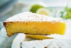 a close up of a piece of cake on a fork with limes in the background