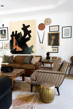 a living room filled with furniture and pictures on the wall