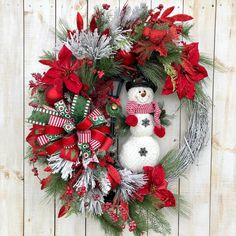 a christmas wreath with a snowman and poinsetti