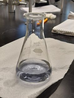 a glass beakle sitting on top of a white napkin next to a black table