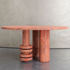 an orange marble table with four columns in front of it and a concrete wall behind it