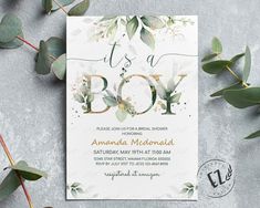 a baby shower is shown with eucalyptus leaves and greenery on the bottom, it's a boy