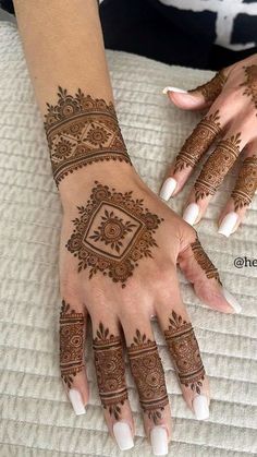 two hands with henna tattoos on them