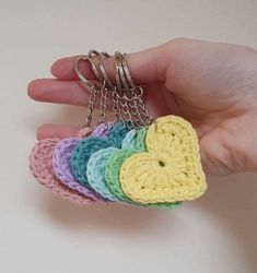 a hand holding a small crocheted heart keychain