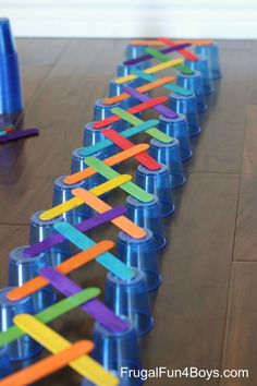 the plastic cups are lined up on the table to make a rainbow - colored chain