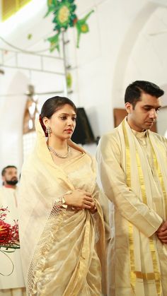 a man and woman standing next to each other in front of a alter at a church