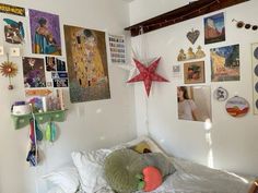 there is a small bed in the room with pictures on the wall and decorations hanging above it