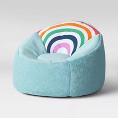 a blue bean bag chair with a rainbow print pillow on the top and bottom, sitting in front of a white background