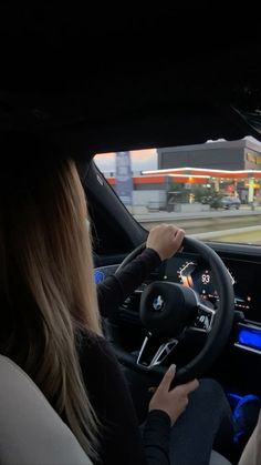 a woman driving a car on a city street