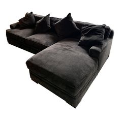 a large black couch with pillows on top of it's back legs and arms