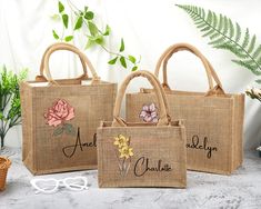 three jute bags with embroidered flowers on them