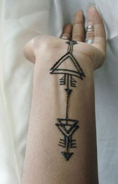 a person's arm with an arrow tattoo on the left side of their arm