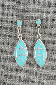 These turquoise and sterling silver inlay earrings were made by Zuni silversmith Orena Leekya. The backs are stamped sterling.Length: 1 1/2"Width: 3/8"Free shipping on all orders! We ship with USPS and always include tracking. All orders ship within a day of payment.Returns are accepted up to 30 days after you receive your order. Just send us a message. Our shop offers cash back or store credit. The item must be returned in new condition. Turquoise Sterling Silver Pierced Earrings, Turquoise Inlay Earrings As Gift, Hallmarked Turquoise Sterling Silver Earrings, Sterling Silver Inlay Earrings, Sterling Silver Drop Earrings With Inlay, Turquoise Inlay Earrings Gift, Blue Sterling Silver Earrings With Inlay, Sterling Silver Dangle Earrings With Inlay, Sterling Silver Inlay Drop Earrings