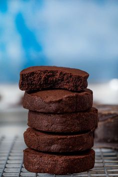 a stack of chocolate cookies sitting on top of a cooling rack