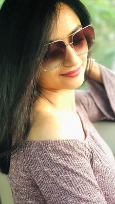 a woman wearing sunglasses sitting in the back seat of a car