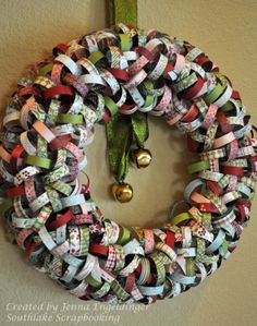 a wreath made out of ribbon and bells hanging on the wall next to a bell