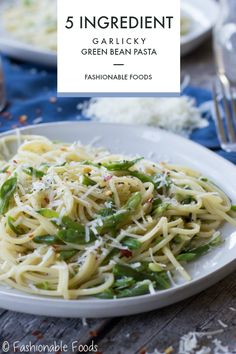 a white plate topped with pasta and green beans