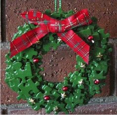 a green wreath hanging on the side of a brick wall