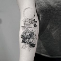 a black and white photo of a woman's arm with flowers on it