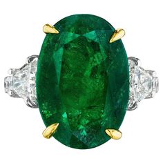 • Platinum & 18KT Two Tone • Size 6.5 • 9.68 Carats • Number of Oval Emeralds: 1 • Carat Weight: 8.54ctw • 16.80 x 11.70mm • Number of Brilliant Trapezoid Diamonds: 2 • Carat Weight: 0.64ctw • Number of Round Diamonds: 10 • Carat Weight: 0.50ctw • This ring showcases an 8.54ct oval cut green emerald center stone. The emerald is flanked by 2 brilliant cut trapezoid diamond side stones, and round diamonds down the band. The green emerald is secured by 18KT yellow gold prongs, highlighting its colo Luxury Green Oval Gemstones, Green Oval Diamond Ring With Vvs Clarity, Gia Certified Oval Emerald Gemstone, Gia Certified Oval Emerald, Gia Certified Oval Green Diamond Ring, Oval Green Diamond Gemstones, Oval Green Gemstones For Formal Occasions, Gia Certified Green Oval Ring, Gia Certified Oval Green Gemstones