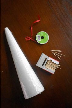 a roll of white paper next to some matches on a table with a red ribbon