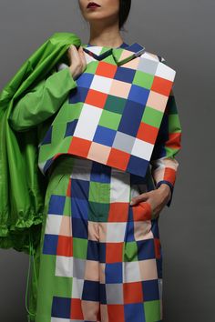 a woman in colorful clothing holding a green jacket