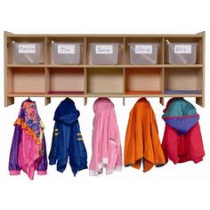 a coat rack with several coats hanging from it's sides and two bins on the other side