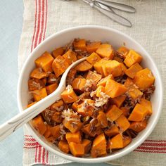 a white bowl filled with lots of food on top of a table