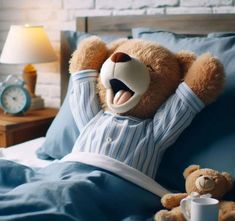 a brown teddy bear laying on top of a bed