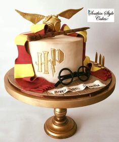 a harry potter themed birthday cake on a gold plate with scissors and other items around it