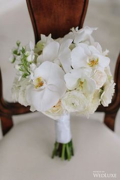 a bouquet of white flowers sitting on top of a chair