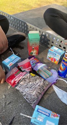 a person is sitting on the ground with some food and other items around him,