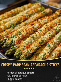 asparagus sticks with parmesan cheese and seasoning in a baking pan