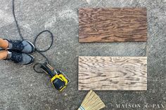 a person standing on the ground next to some wood planks and a power drill