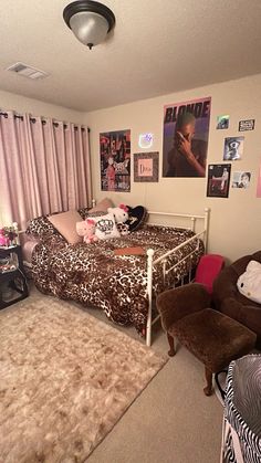 a bedroom with pink curtains, leopard print bedspread and brown chair in the corner